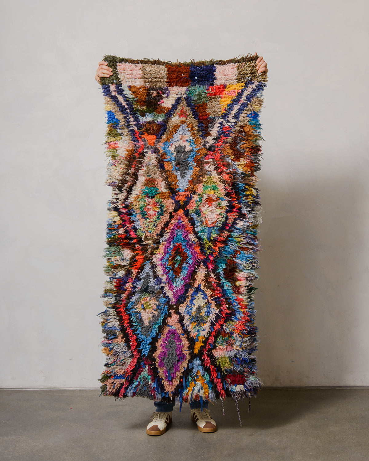 Multicolored textured rug with geometric pattern on a plain background